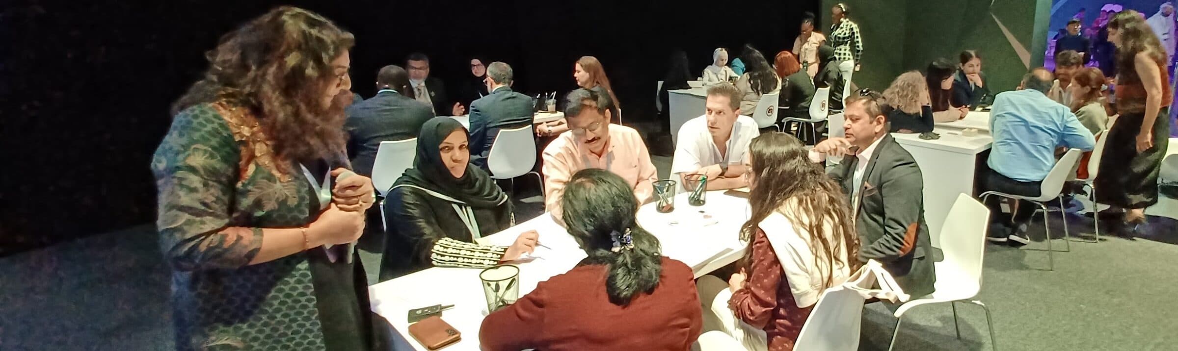 International educators in discussion around tables at an EdTech Impact research event